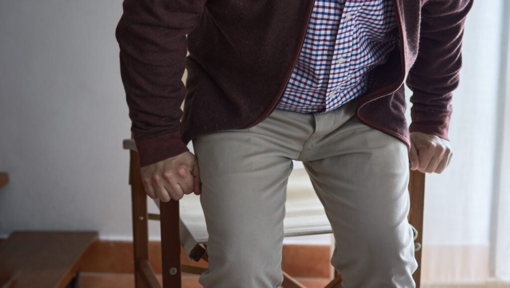 an older adult has difficulty getting up from an chair in the living room