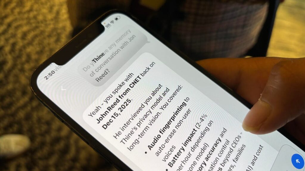 A person holds a phone in which a chatbot recaps a conversation.