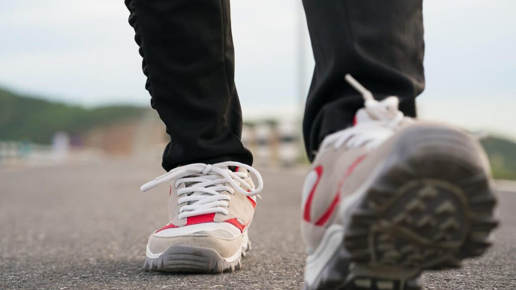 Two feet in walking shoes on pavement