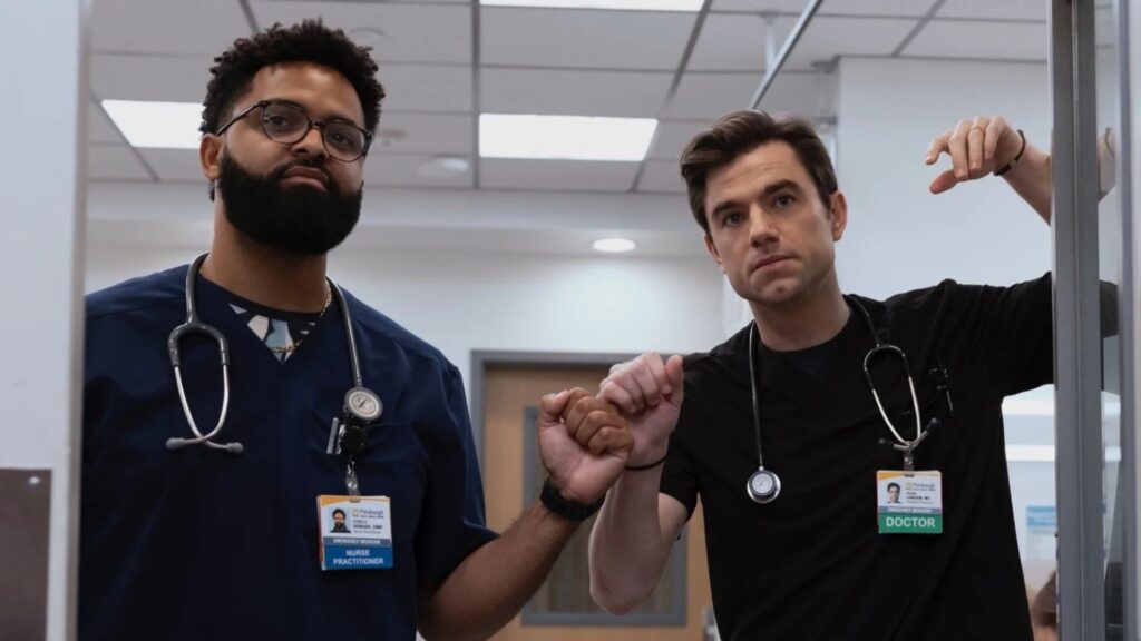Langdon fist bumps a male nurse while leaning on a door frame