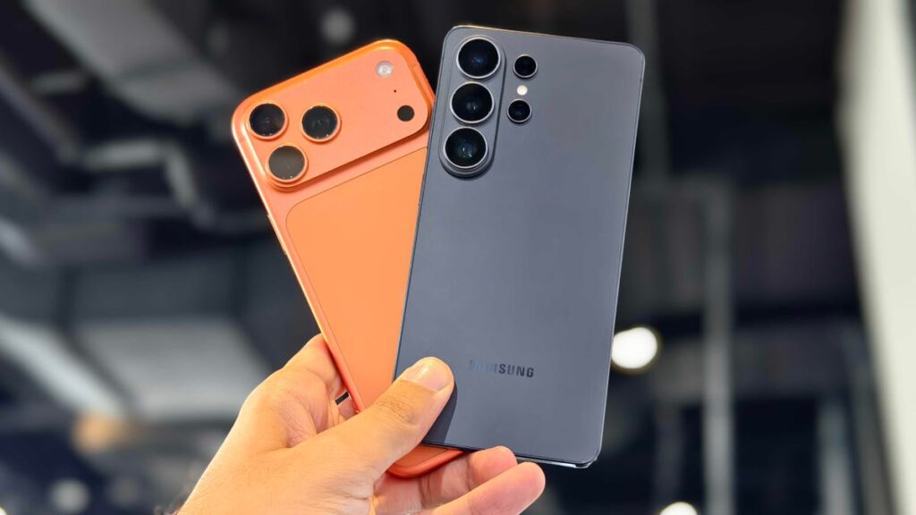 Samsung’s Galaxy S26 Phones Will Work With Apple’s AirDrop, Much Like the Pixel 10 Prakhar holding the iPhone 17 Pro Max and Galaxy S26 Ultra.