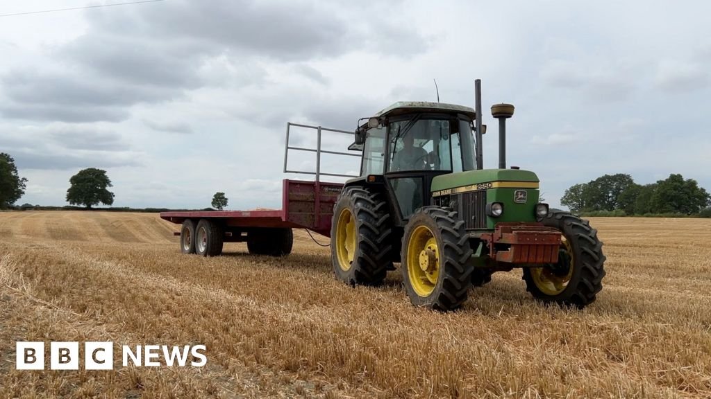 Farmwatch: Farmer on mental health issues A farmer in a green tractor pulling a red trailer