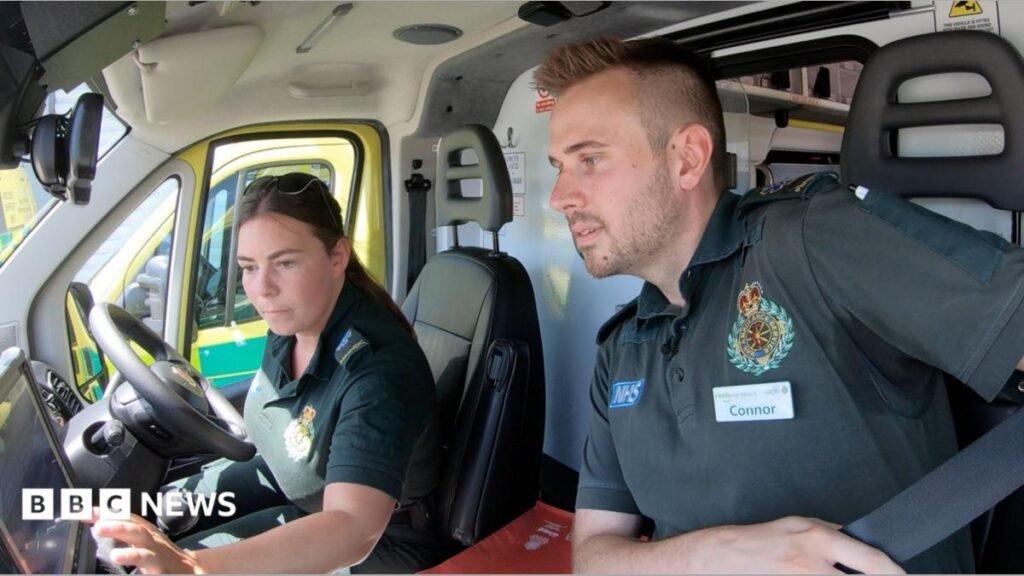 Two paramedics visit a middle aged man who is struggling to breathe. He has an oxygen mask on while the paramedics check his notes