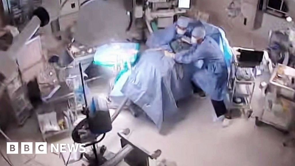Moment earthquake shakes hospital operating room in Japan CCTV image of an operating room with doctor falling over and grabbing the operating table