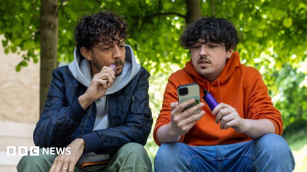 Nicotine vapes best chance to quit smoking, major review finds Two young men sit outside vaping. They are chatting, while looking at a mobile phone.