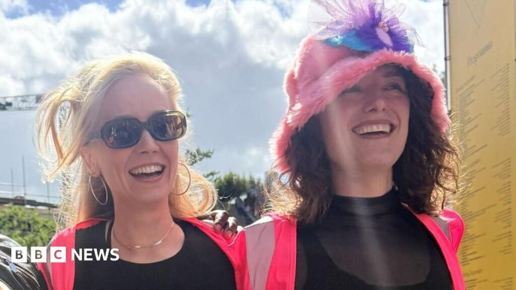'Make women feel seen': Why the Dutch have a new word for labia A person with brown hair, holding a mic smiling. She wears red trousers and a blue shirt. She also has a merkin - or pubic hair wig - over her clothes. Behind her is a large blue and orange cloth sign used on a march to celebrate a new Dutch word for labia.