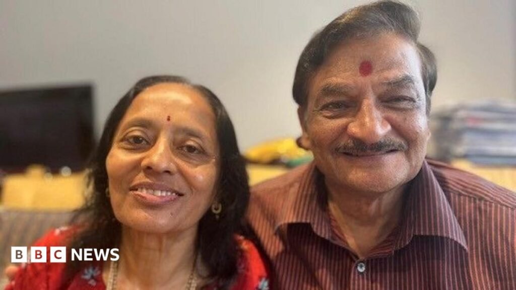 Sock sensors and smart mattresses – is this the future of dementia care? A hindu couple are looking straight at the camera and smiling. The woman is wearing a red top with flowers on it, she has thin black hair just past her shoulders and she has a small red dot called a bindi in the middle of her forehead. Her husband has his arm around here and is wearing a maroon verticle striped shirt and has a large bindi on his forehead.