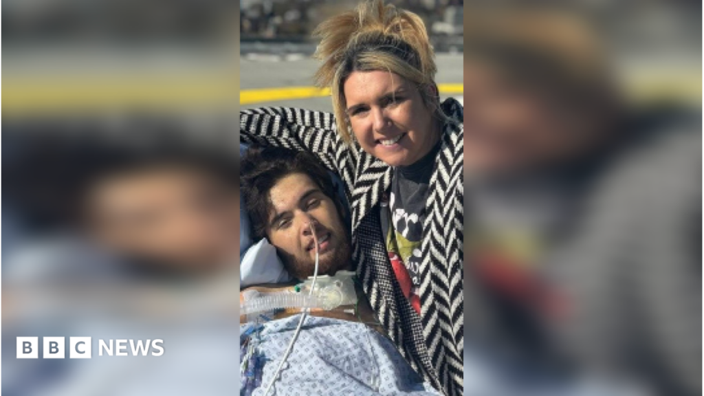 Student almost dies after accidental paracetamol overdose Riley Lubas sat in a chair covered in medical equipment. A woman is sat next to him.