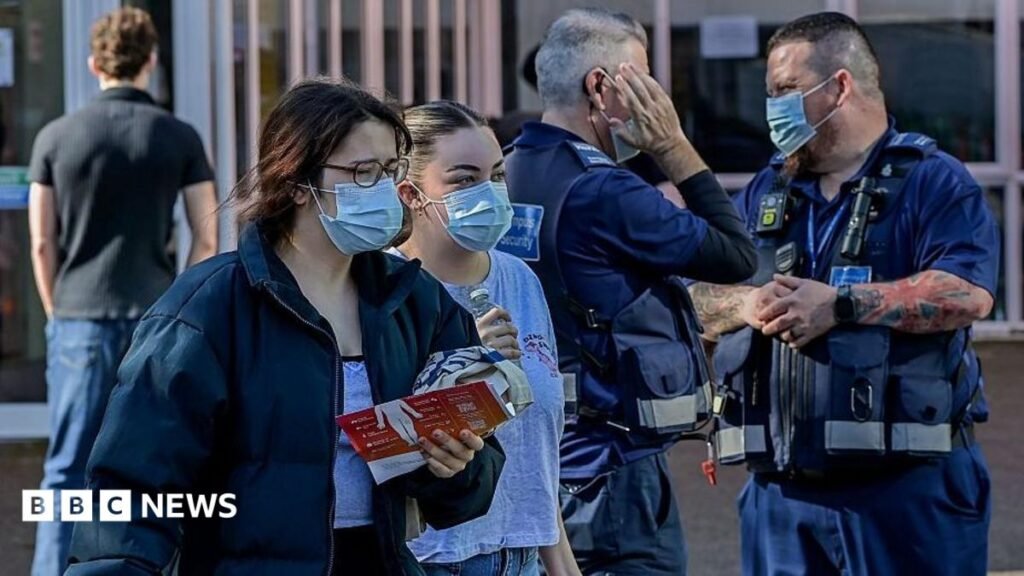 Two young women and two male health officials wearing surgical face masks